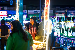 People visiting a holiday light display at night.