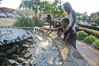 girls playing in fountain