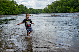 boy wading through lake
