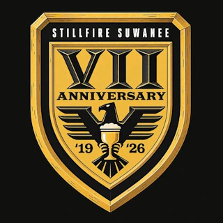 Gold shield logo with VII Anniversary, an eagle, a glass, and years 19 and 26. StillFire Suwanee above.